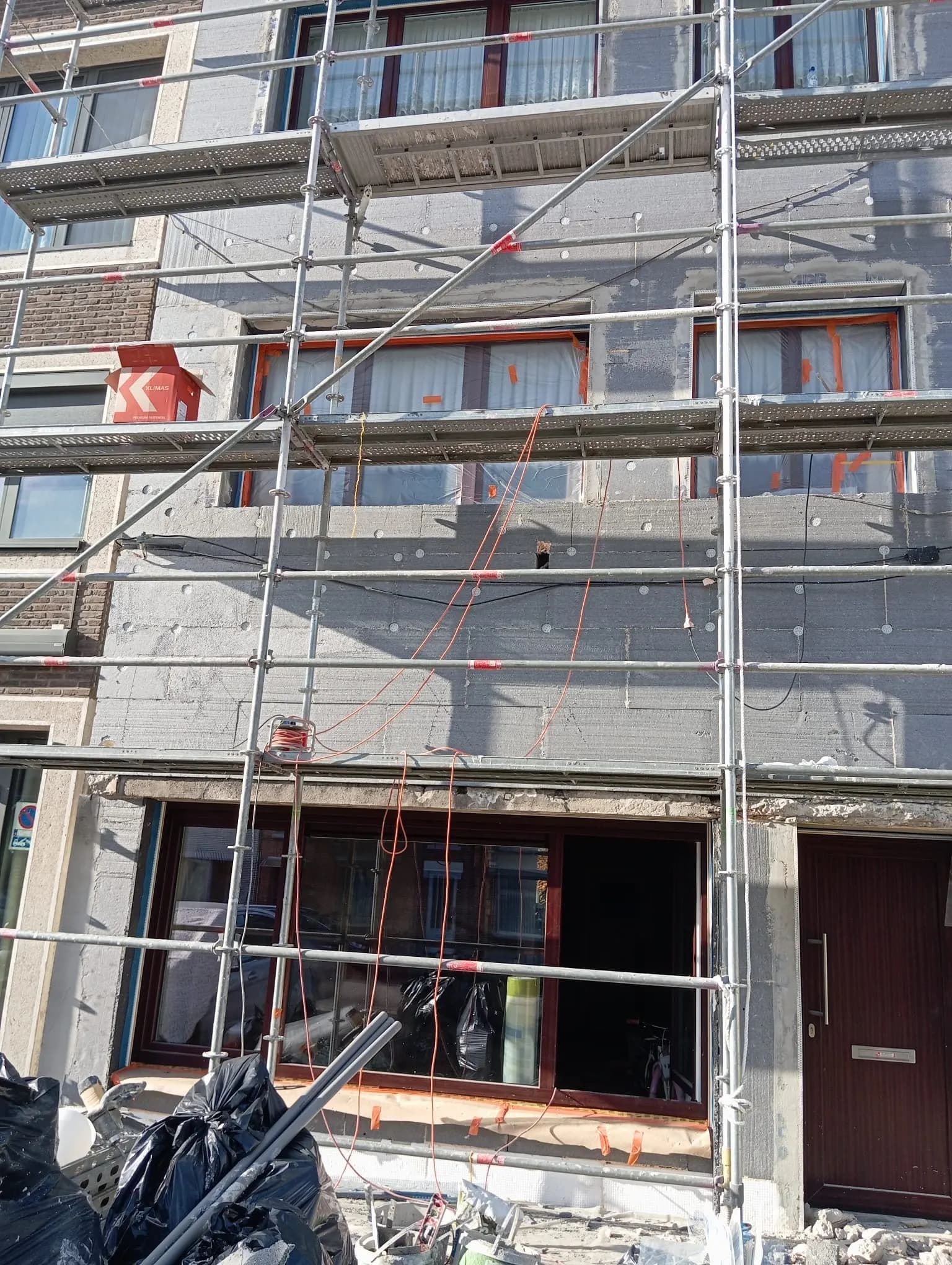 Façade entièrement recouverte de panneaux isolants et de chevilles, prête pour la couche d'armature